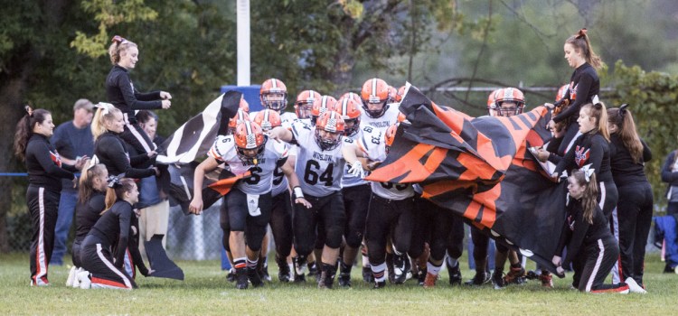 The Winslow football team storms on to Keyes Field in Fairfield prior to a game last season gainst rival Lawrence.