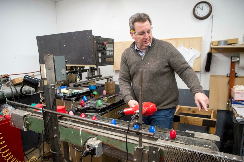 Michael Conway, director of marketing and sales at Maine Wood Concepts in New Vineyard, explains the painting process Friday on the Easter egg production line.