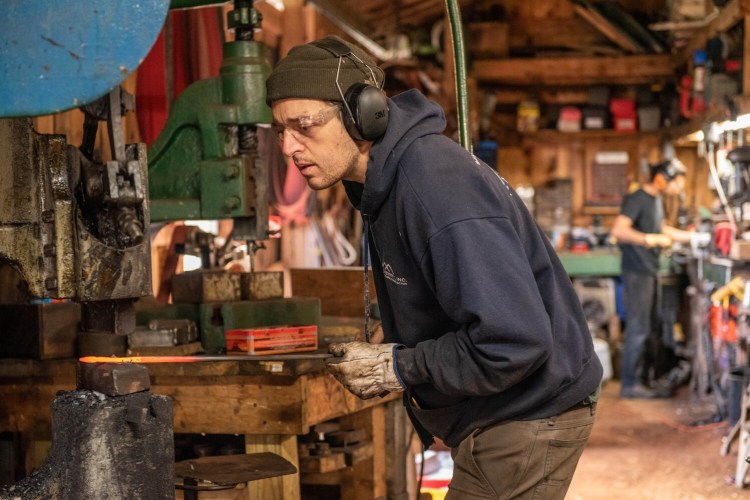 Nicholas Wicks Moreau shapes the end of a fireplace tool on Tuesday at Wicks Forge in Pownal. Moreau is a third generation blacksmith and has seen his business grow quickly after starting to sell items on Etsy.