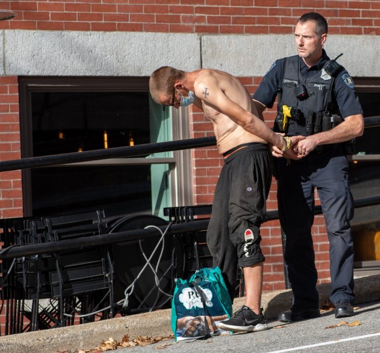 Lewiston Police Officer Jeff Burkhardt detains Alexander Madore, 33, Thursday afternoon on Ash Street in Lewiston after he was suspected of crashing a vehicle on Main Street and fleeing.