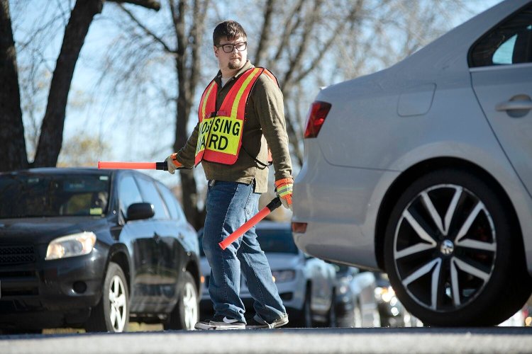 Josh Harris directs traffic Nov. 1 as parents pick up their children from Auburn Middle School.