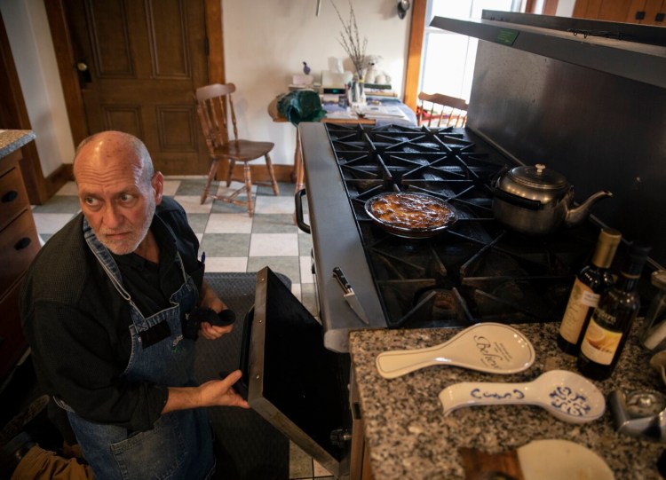 NEW GLOUCESTER, ME - DECEMBER 7: Brother Arnold pulls out the Plum Kuchen from the oven at Shaker Village on Tuesday, December 7, 2021. Brother Arnold’s mother always made the dessert at Christmastime and he continues his family’s holiday tradition at Shaker Village. (Staff photo by Brianna Soukup/Staff Photographer)