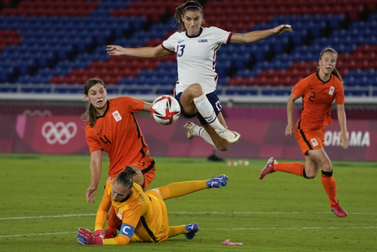 Alex Morgan jumps over Netherlands' goalkeeper Sari van Veenendaal as she attempts to score during a women's quarterfinal soccer match at the 2020 Summer Olympics in Yokohama, Japan. 