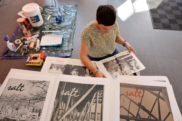 PORTLAND, ME - SEPTEMBER 21: Mira Ptacin (cq), an alum of the Salt Institute of Documentary Studies, flips through a copy of Salt magazine at Maine College of ArtÕs 49 Oak Gallery, which will soon display posters and magazines to celebrate the 50th anniversary of the institute. (Staff photo by Ben McCanna/Staff Photographer)